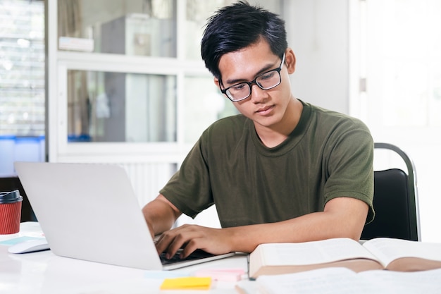 Молодой студент коллажа, использующий компьютер и мобильное устройство, обучающийся онлайн. Образование и онлайн-обучение.