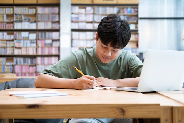 Young collage student using computer and mobile device studying online. Education and online learning.