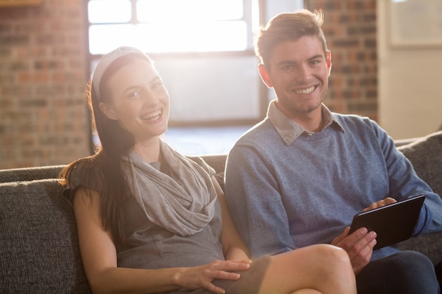 Young colleagues sitting on sofa in office