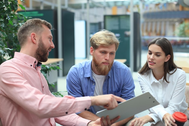 Young colleagues in smart casual wear working while spending time in the office.