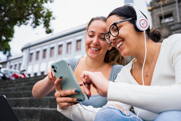 Young college friends looking at phone on campus