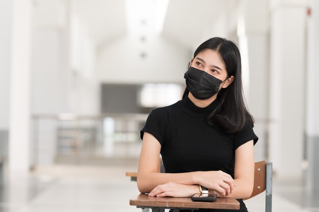 Giovane studente di college che indossa una maschera di panno nero, torna a scuola,