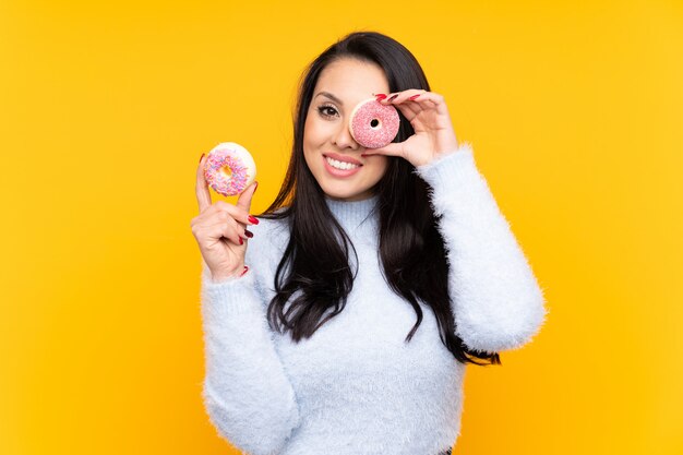 Young Colombian girl holding a donut and happy