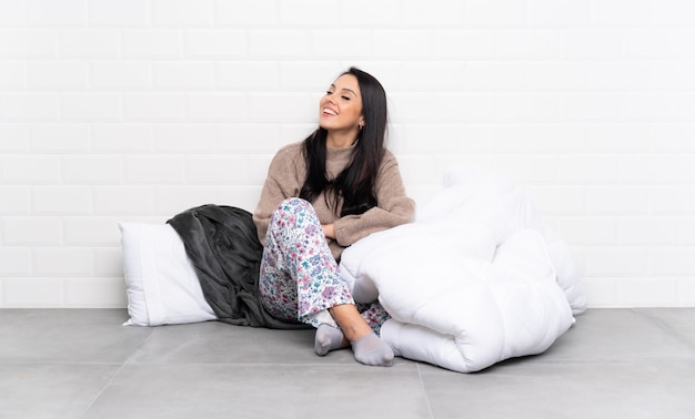 Young Colombian girl in pajamas at indoors happy and smiling