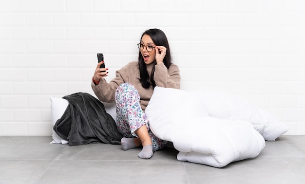 Young Colombian girl in pajamas at indoors making a selfie