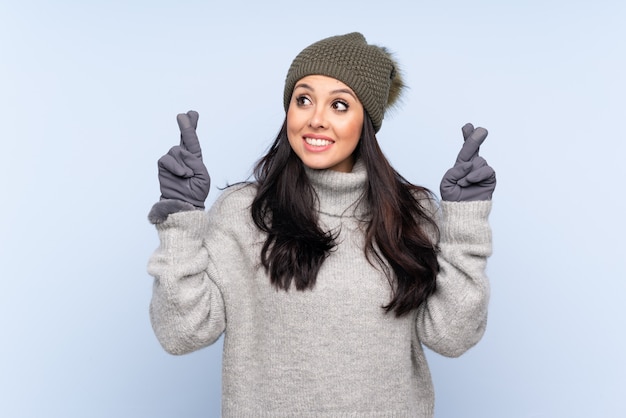 Foto giovane ragazza colombiana con cappello invernale con incrocio le dita