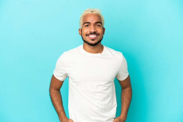 Photo young colombian handsome man isolated on blue background laughing