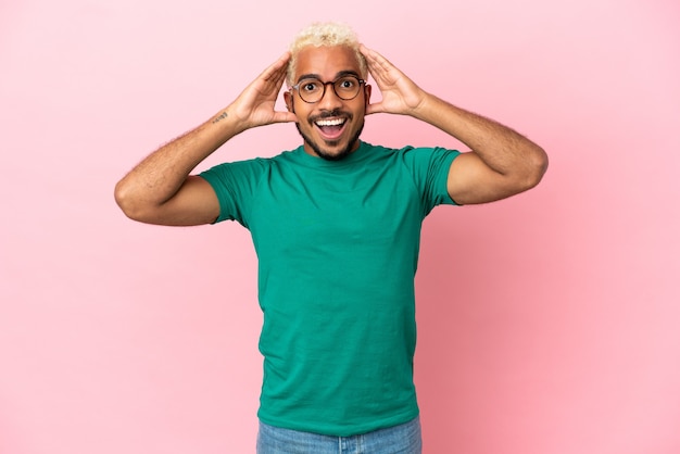 Young Colombian handsome man isolated on pink background with surprise expression
