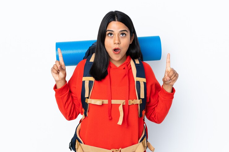 फोटो young colombian mountaineer woman with a big backpack isolated on white wall pointing with the index finger a great idea