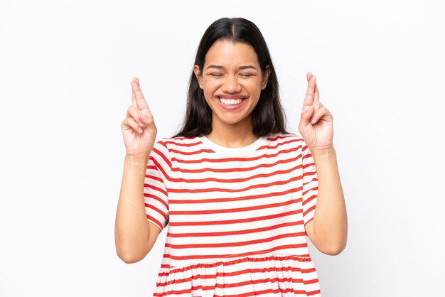 Young Colombian woman isolated on white background with fingers crossing