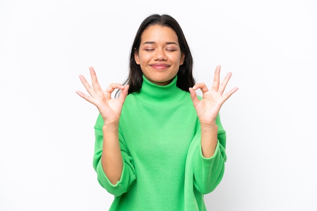 Young Colombian woman isolated on white background in zen pose