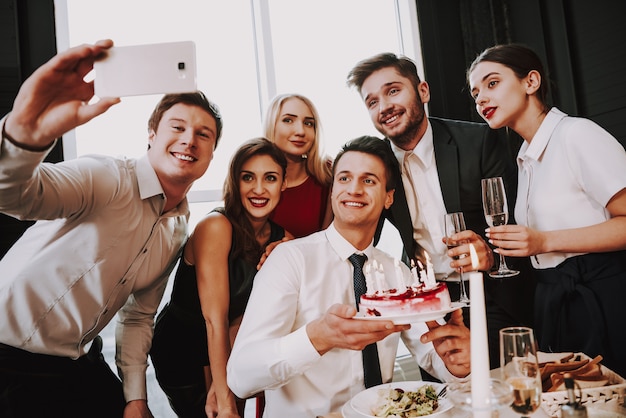 Azienda giovane che fa selfie sul compleanno degli amici.