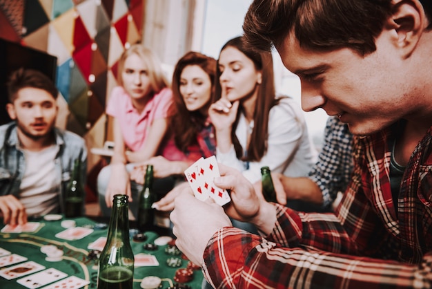 Young Company Playing Holdem Poker On A Party