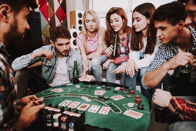 Giovane azienda che gioca il poker di holdem su un partito.