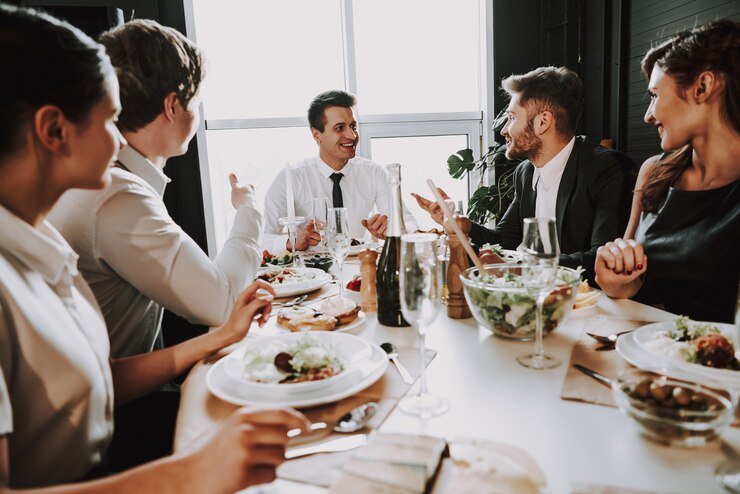 Photo young company sits in suits around dinner table