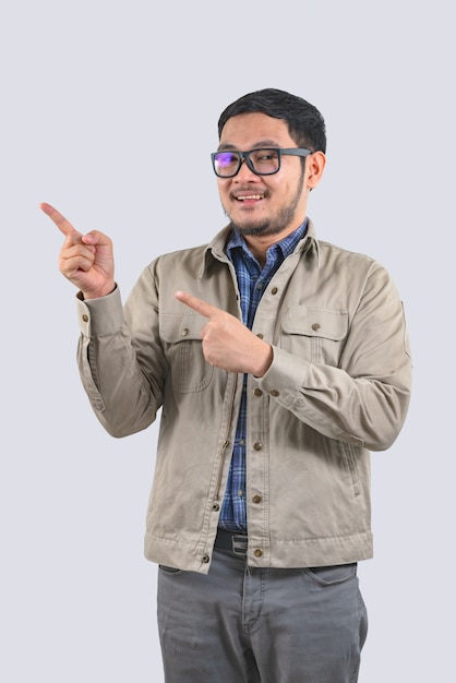 Young computer engineer asian man is pointing to an empty space on the left