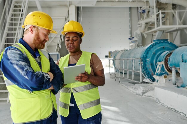 Young confident black woman showing her male colleague online data