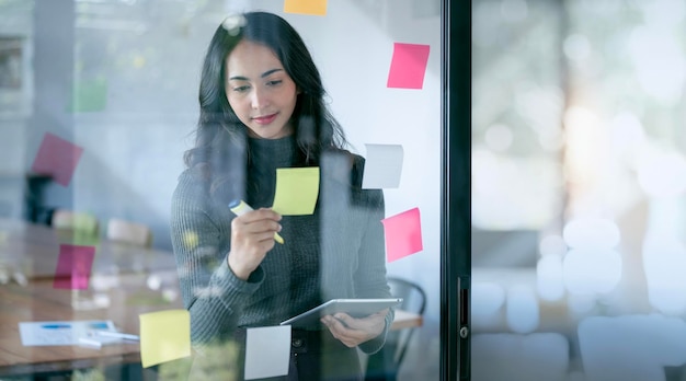 Young confident Businesswoman planning with adhesive notes in creative office