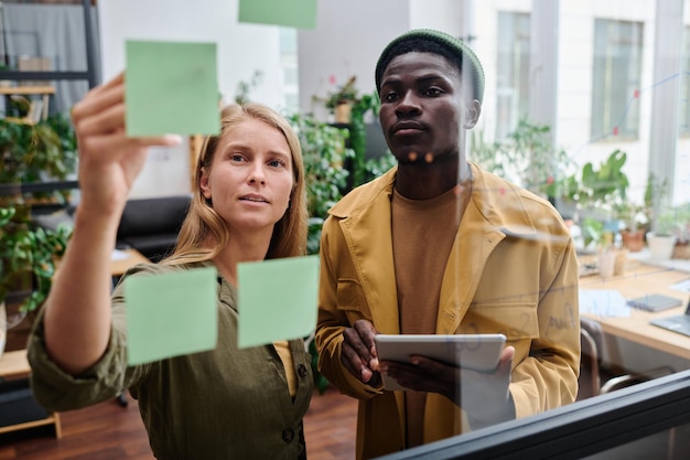 Young confident businesswoman pointing at notepaper with working tasks