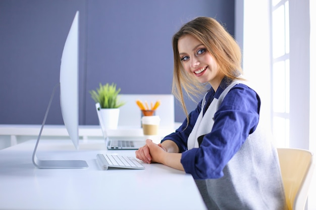 young confident businesswoman working at office desk and typing with a laptop