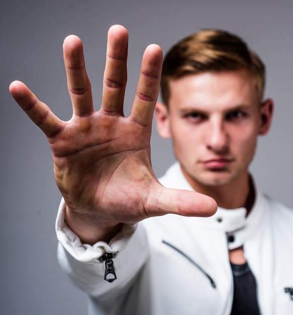 Young confident guy in white urban clothes with open hand gesture