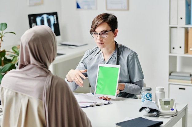 Young confident healthcare worker holding tablet during medical presentation