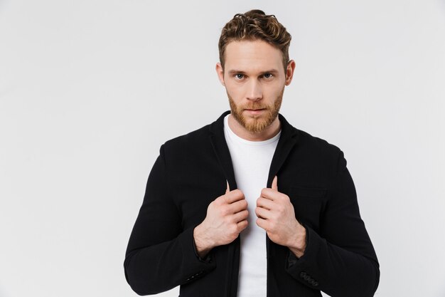 young confident man in jacket posing and looking at front isolated over white wall