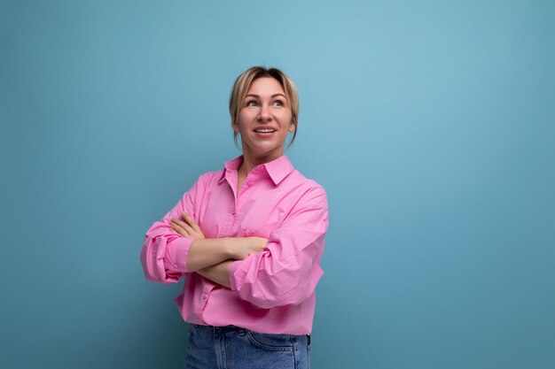 Young confident smart european blond office worker woman wearing pink shirt and jeans over isolated