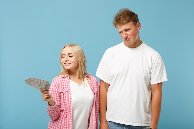 Young confused couple two friends guy and woman in white pink t-shirts posing 