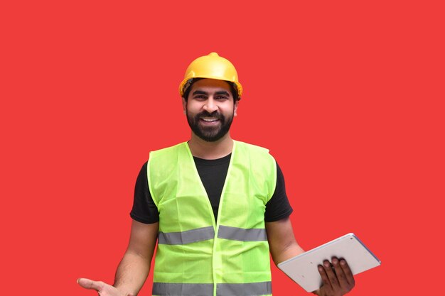 young construction worker feeling happy and holding tab indian pakistani model