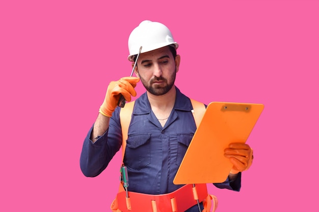 young construction worker holding screwdriver and clipboard indian pakistani model