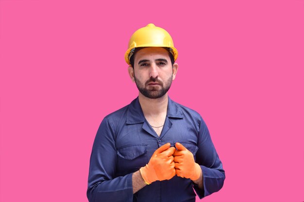 Photo young construction worker posing over pink background indian pakistani model