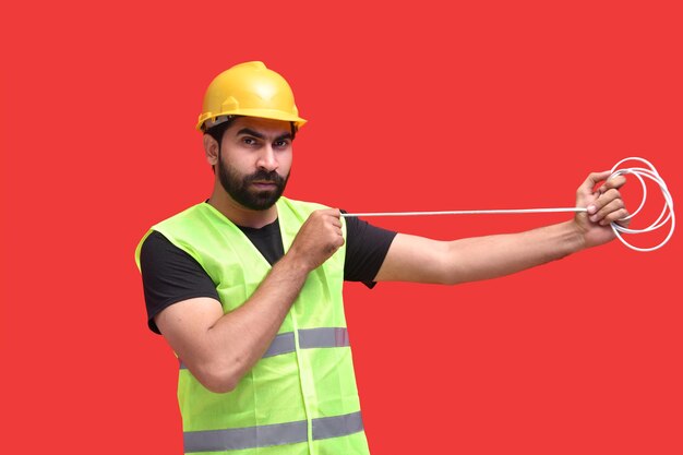 young construction worker stretching wire with hands indian pakistani model