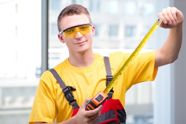 Young construction worker in yellow coveralls