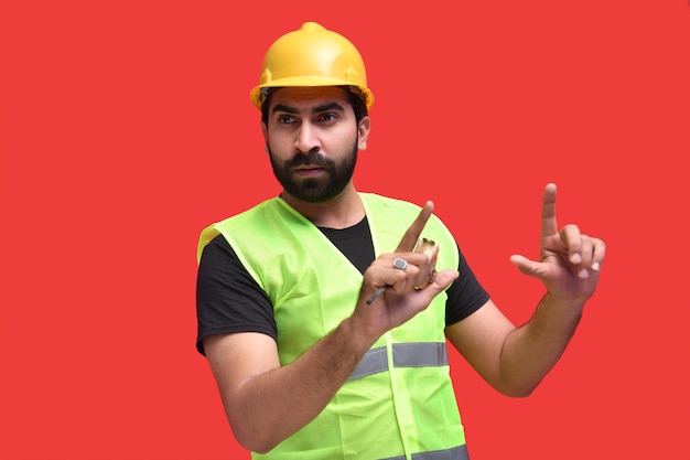 Photo young constrution wearing safety vest and halmet posing over indian pakistani model