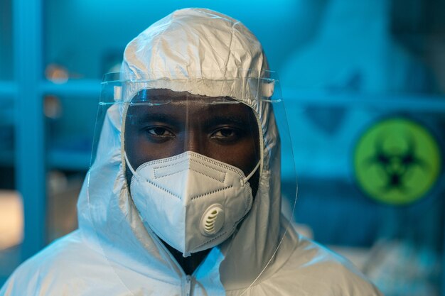 Young contemporary african american scientist in coveralls and respirator