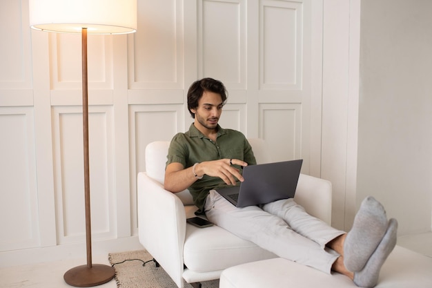 Young contemporary businessman looking at laptop screen during video call