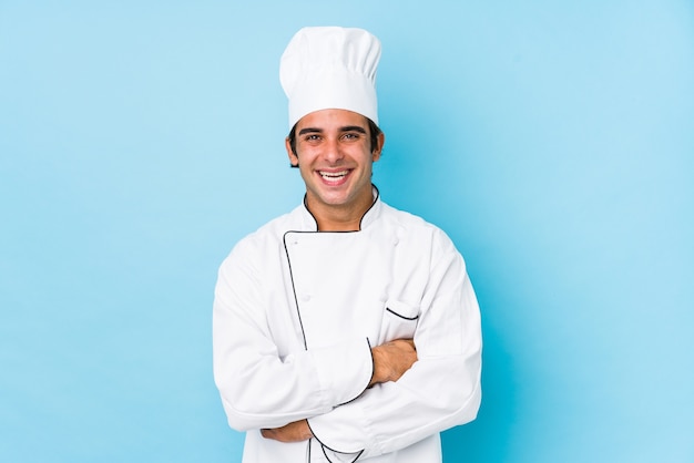 Young cook man isolated laughing and having fun.