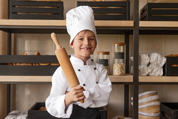 Young cook standing in kitchen of bakery