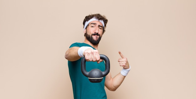 Young cool bearded man at gym with a dumbbell. sport concept