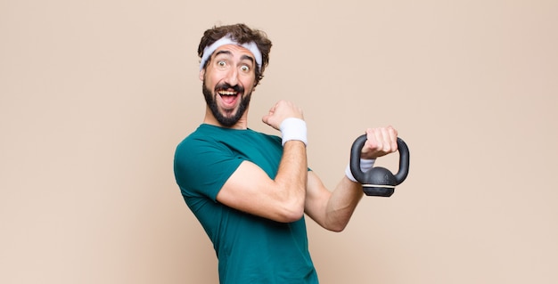 Young cool bearded man at gym with a dumbbell. 