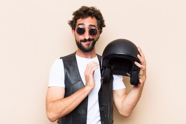 Young cool bearded man holding his helmet