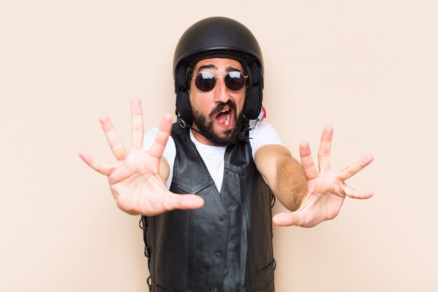 Young cool bearded man with a helmet and scared expression
