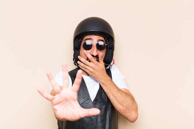 Young cool bearded man with a helmet and scared expression