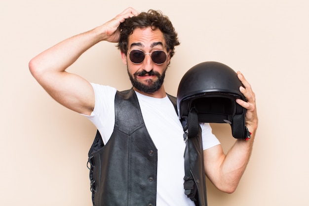 Photo young cool bearded man with a helmet and scared expression