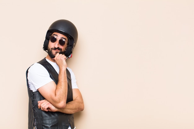 Young cool bearded man with a helmet thinking