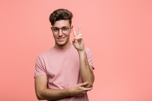 Young cool caucasian man showing number two with fingers.