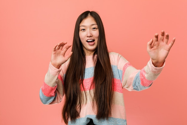 Young cool chinese woman being shocked due to an imminent danger