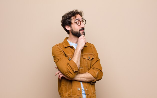 Young cool and crazy man against flat wall