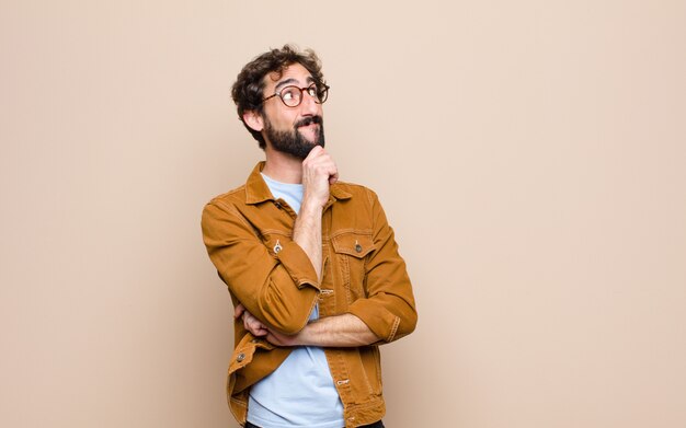 Young cool and crazy man against flat wall